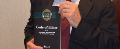 Man Holding Copy NASW Code Of Ethics